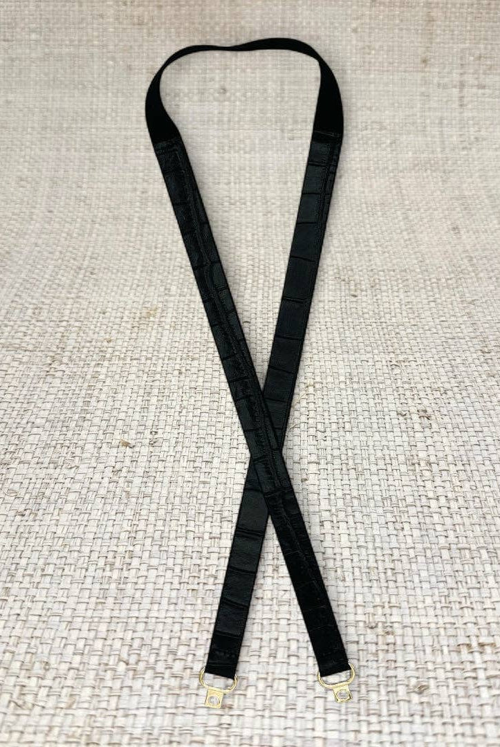 Black skinny leather belt from Garland Bags, close-up view showing sleek design and smooth leather strap.