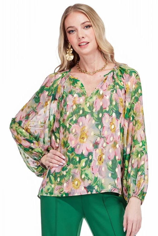 Woman wearing a floral blouse with green pants on a white background