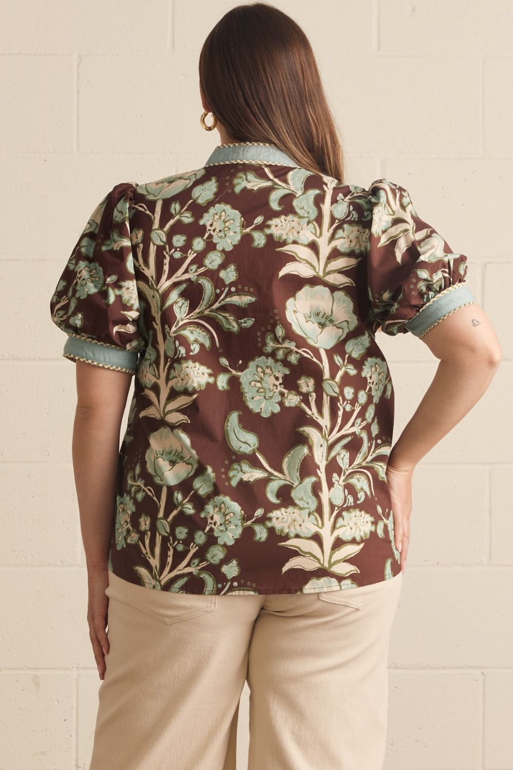Entro Mabel Top in chocolate brown botanical floral print, short puff sleeves with powder blue contrast cuffs and braided trim, back view
