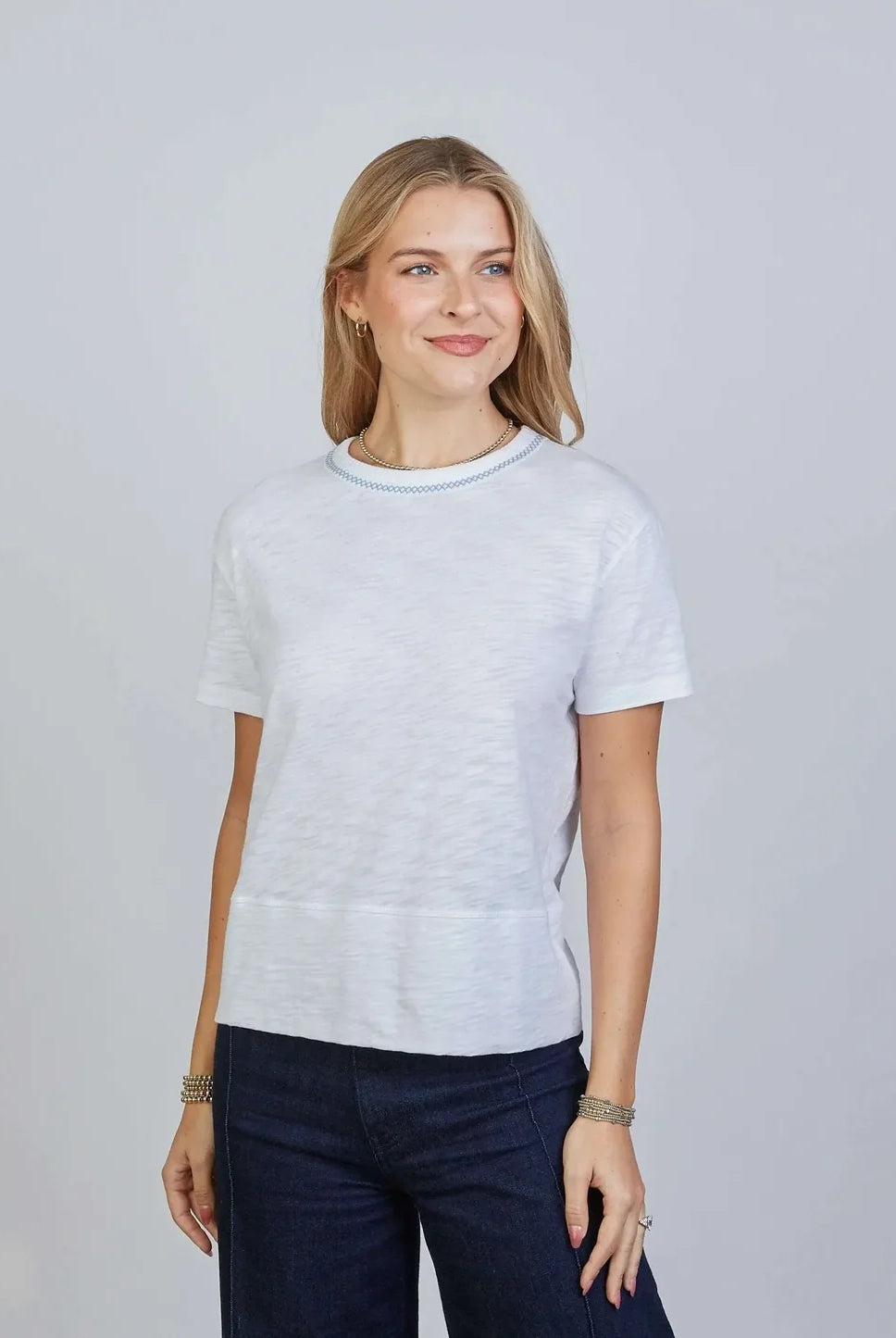 White Erin Gray Charli Tee top with blue stitching, casual short-sleeve design, soft fabric, and stylish contrast details.