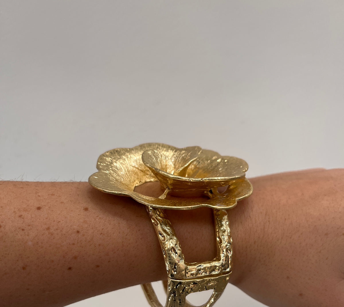 textured gold cuff bracelet with rose shaped flower