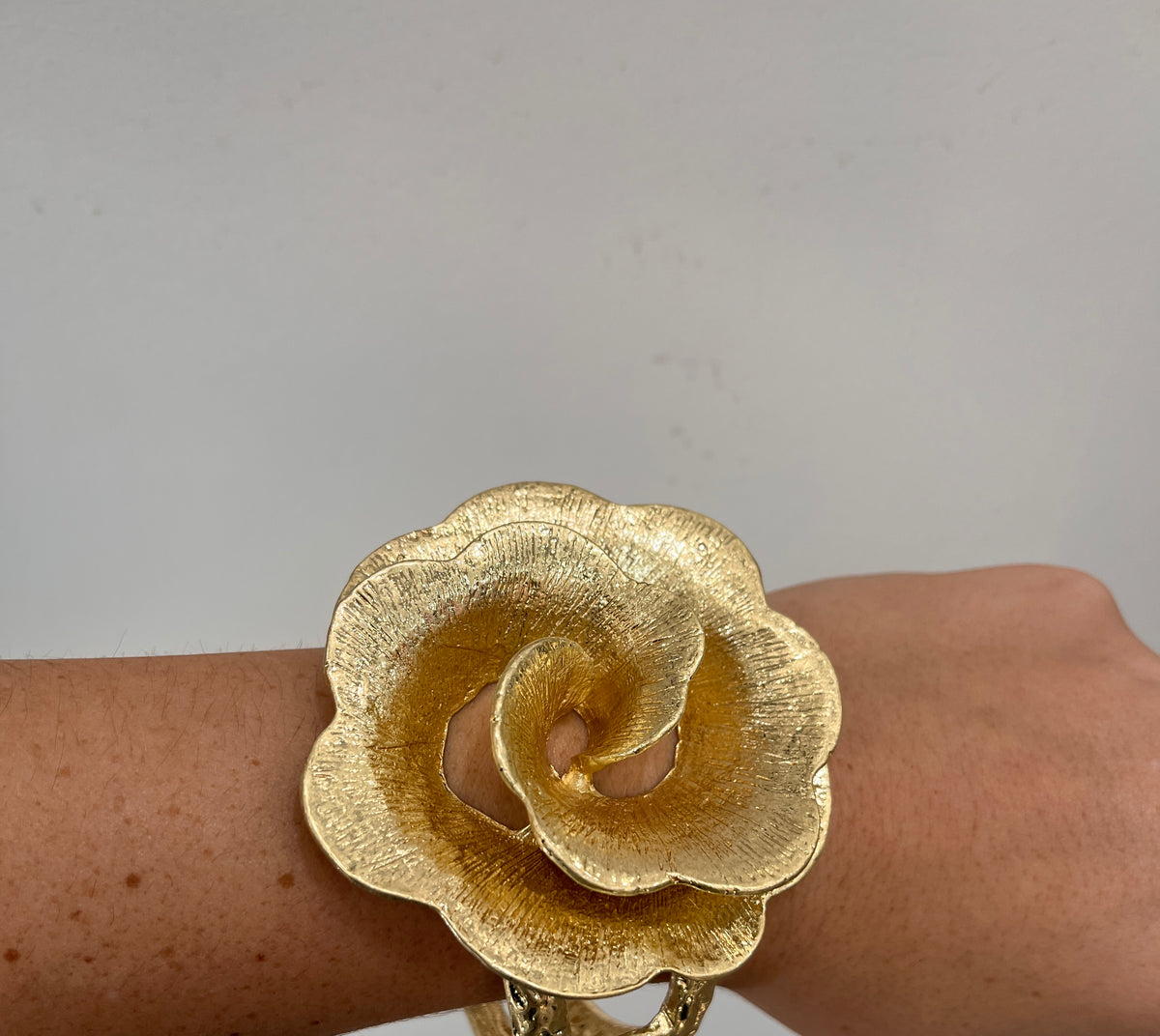 textured gold cuff bracelet with rose shaped flower