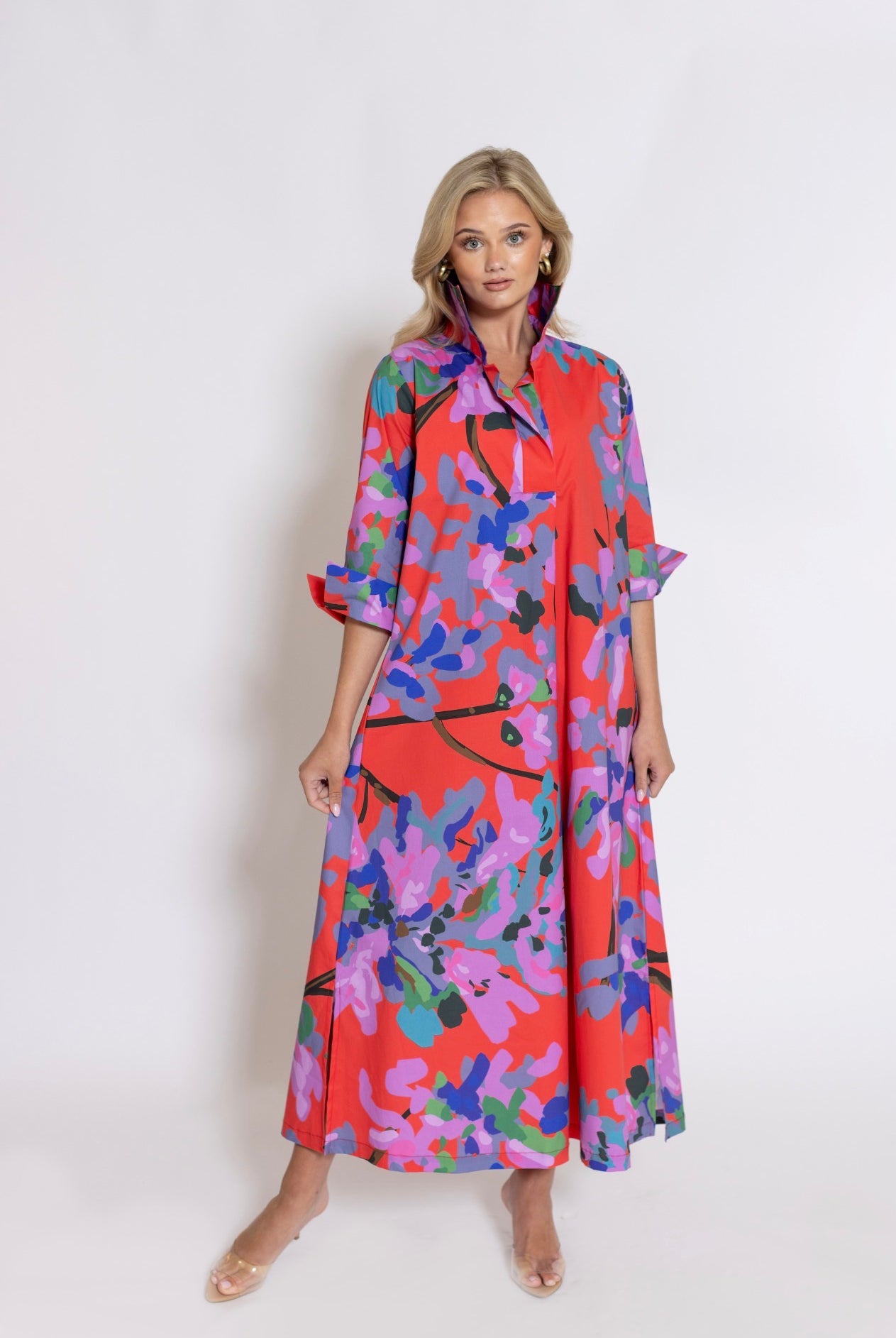 Miss Scarlet Ruthie Shirt Dress Long by House of MBR, front view, maxi shirt dress, bold red base with abstract floral print in lavender purple blue teal and green, shirt collar, 3/4 sleeves with split cuffs, relaxed A-line silhouette