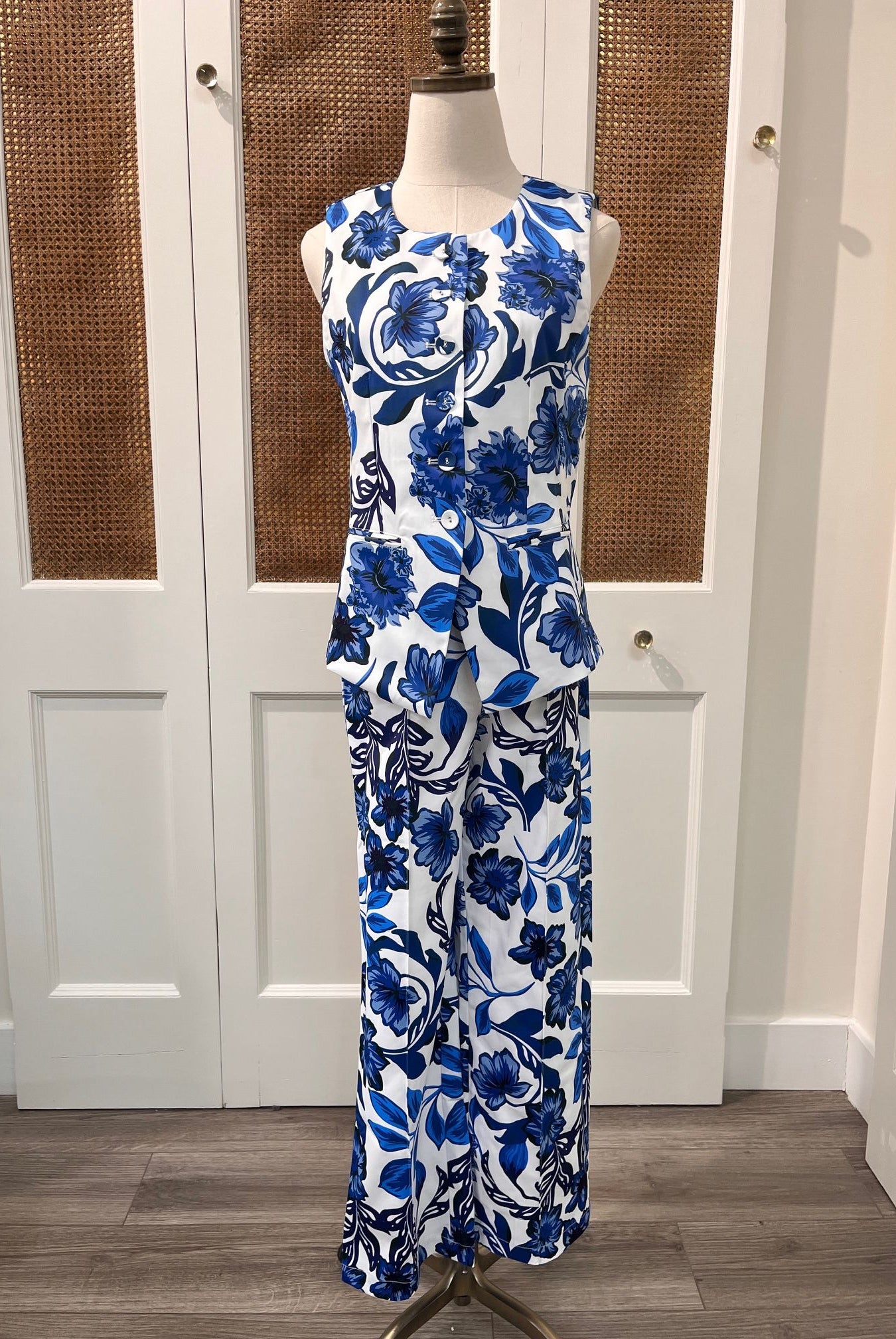 JADE Gladys top, stylish women's sleeveless blouse with floral pattern and V-neck, hanging on a hanger.