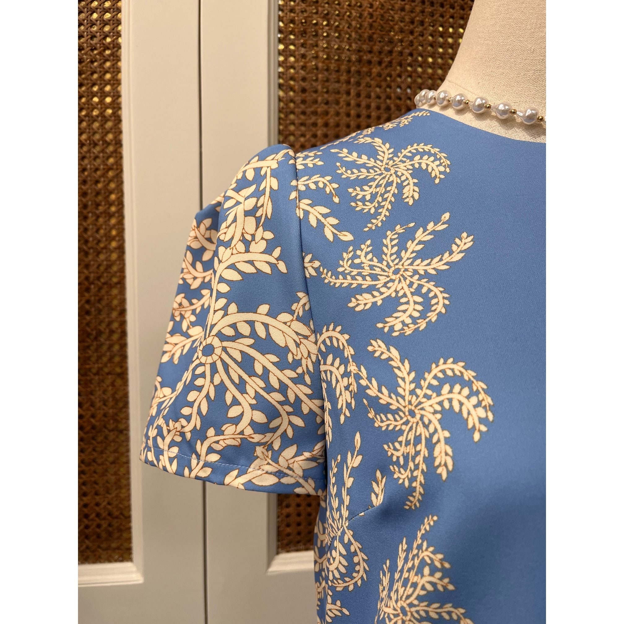 JADE Vera dress displayed on a mannequin, featuring a stylish, flowy design with a V-neck and short sleeves.