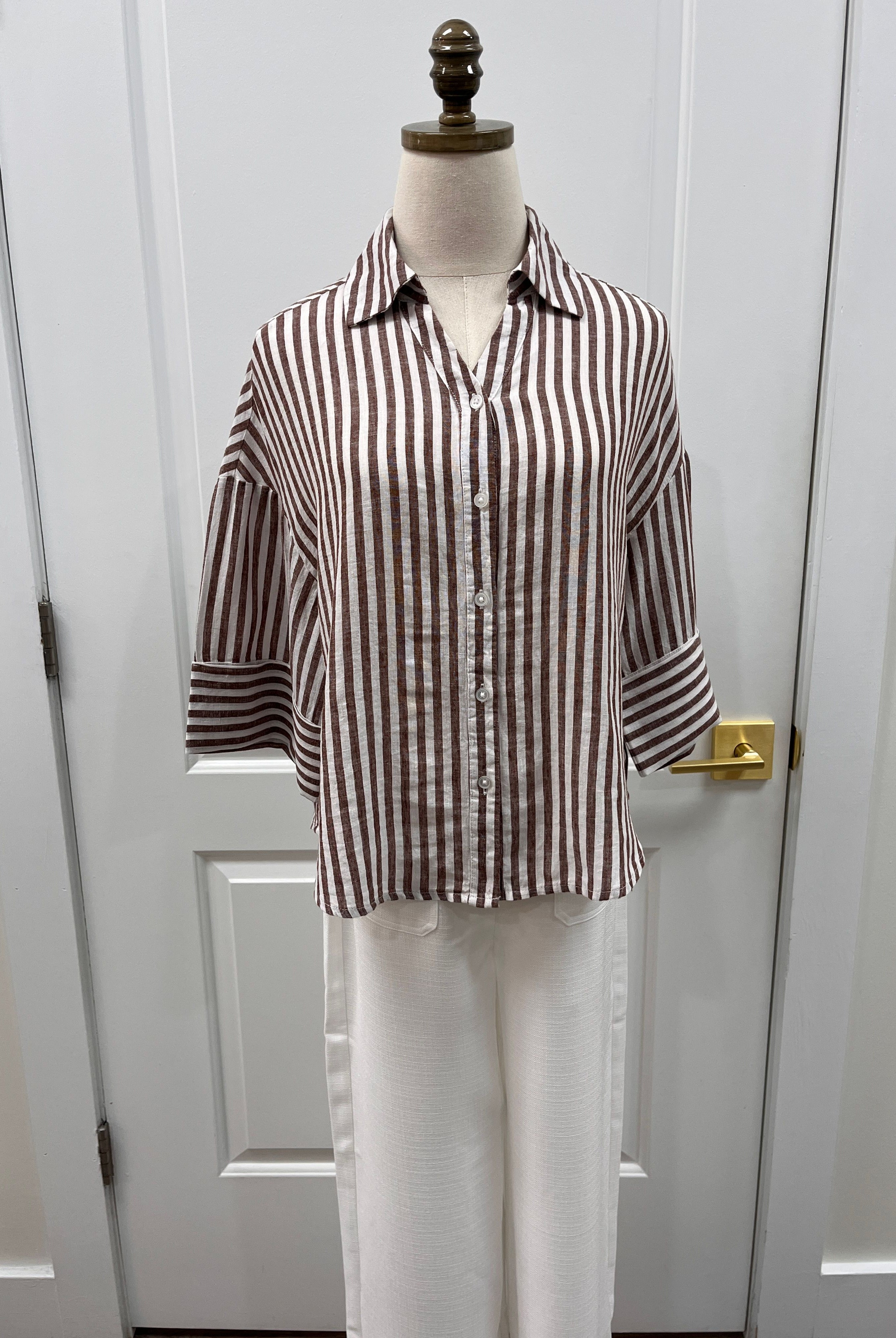 Lola River Pixel Top displayed on a hanger, featuring a vibrant pixelated pattern and casual fit.
