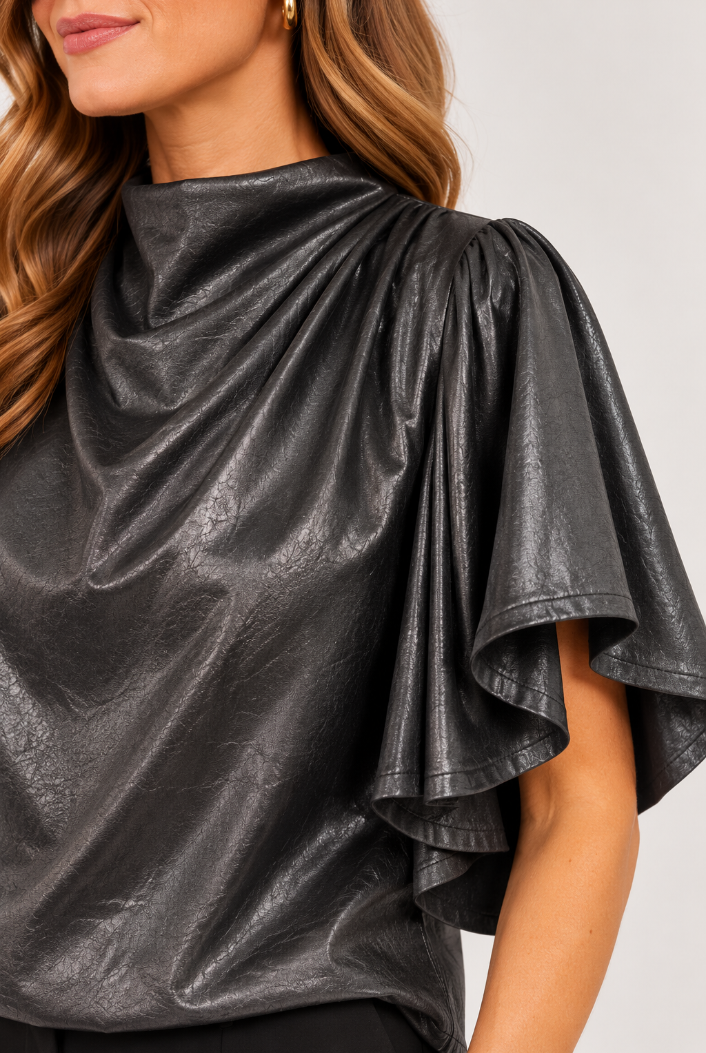 Close-up of the pleated shoulder and textured faux-leather finish on black Veronica Top, Style #WCT4008-1⠋
