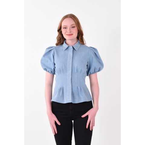 The Britt Top redefines denim with a feminine edge. Featuring a classic fold collar, puff sleeves with elastic cuffs, and a lightly boned bodice, this style offers both structure and ease. A concealed front button closure is framed by a gold-studded panel, adding a subtle western-inspired detail. Crafted in stretch denim, it flatters the figure while providing comfort, making it as timeless as it is on trend. Pair with the matching Paisley Pant for a full denim look that’s effortlessly chic and designed to