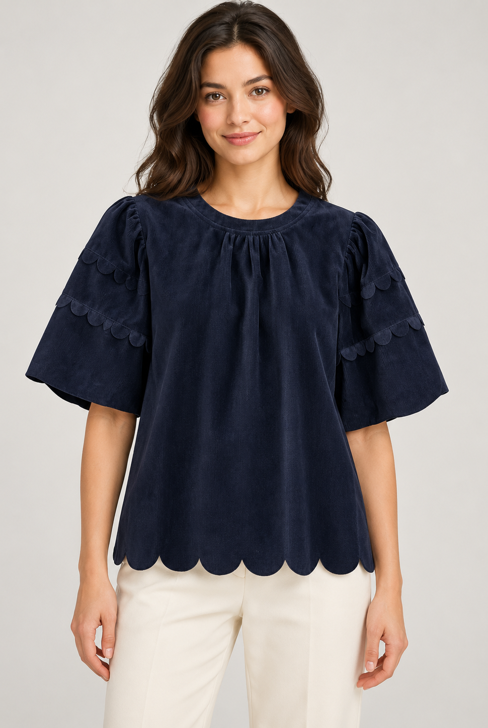 Greer Top by Voy in navy corduroy on a model, front view with gathered neckline, scalloped sleeve trim and scalloped hem
