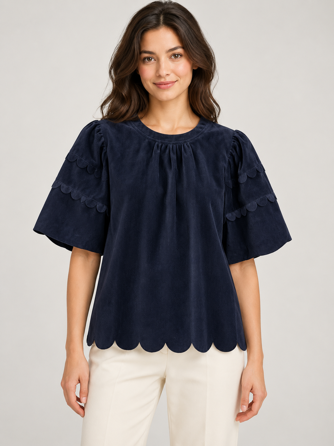 Greer Top by Voy in navy corduroy on a model, front view with gathered neckline, scalloped sleeve trim and scalloped hem
