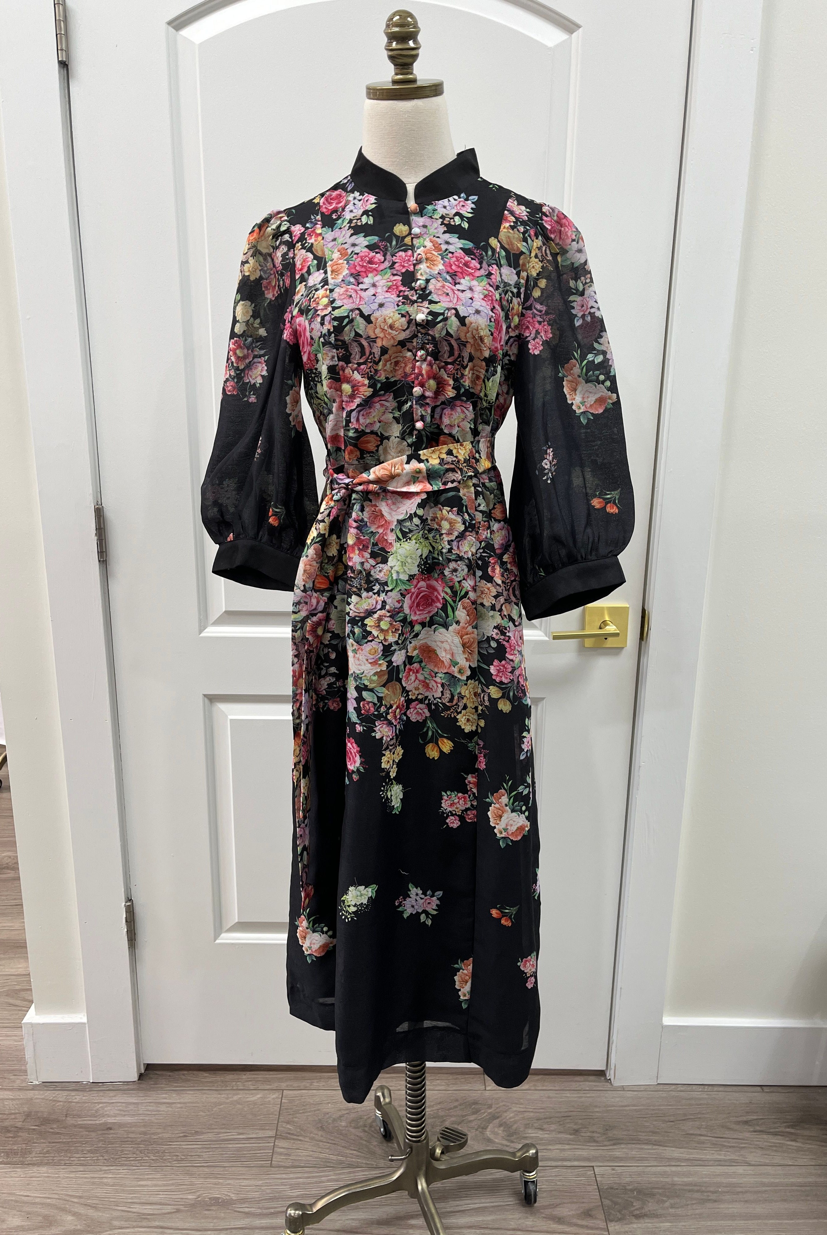 Black floral JADE Nora dress with a fitted bodice and flowing skirt, perfect for casual or semi-formal occasions.