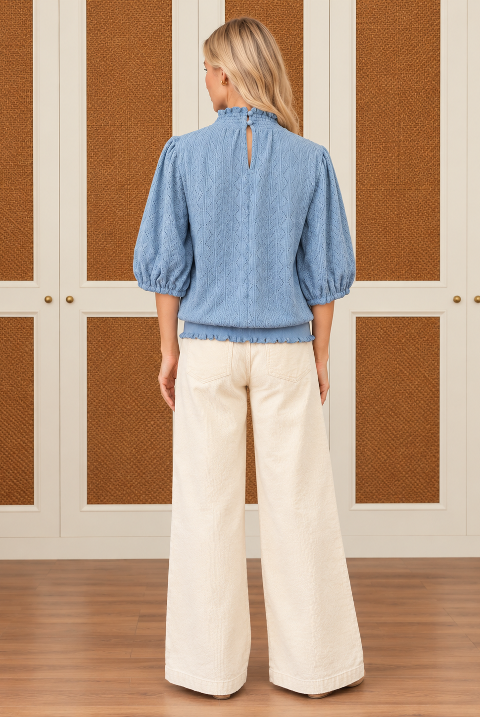 Alice Top by Voy in light blue textured knit with a smocked high neck, puff sleeves, and ruffled hem, back view