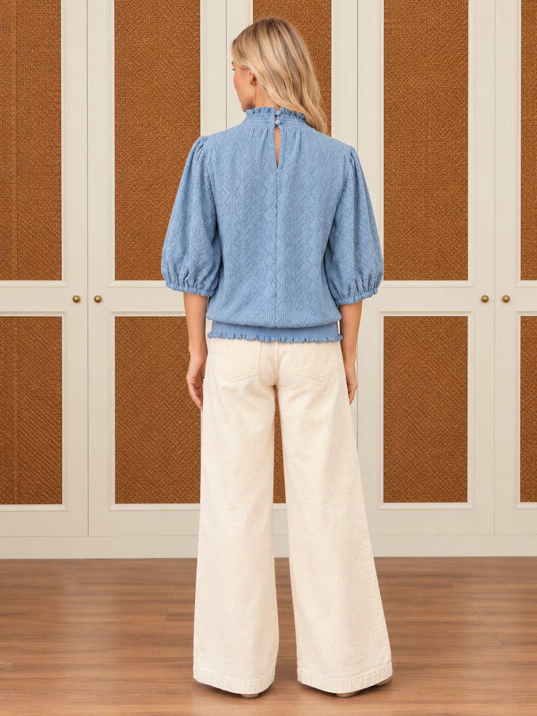 Alice Top by Voy in light blue textured knit with a smocked high neck, puff sleeves, and ruffled hem, back view
