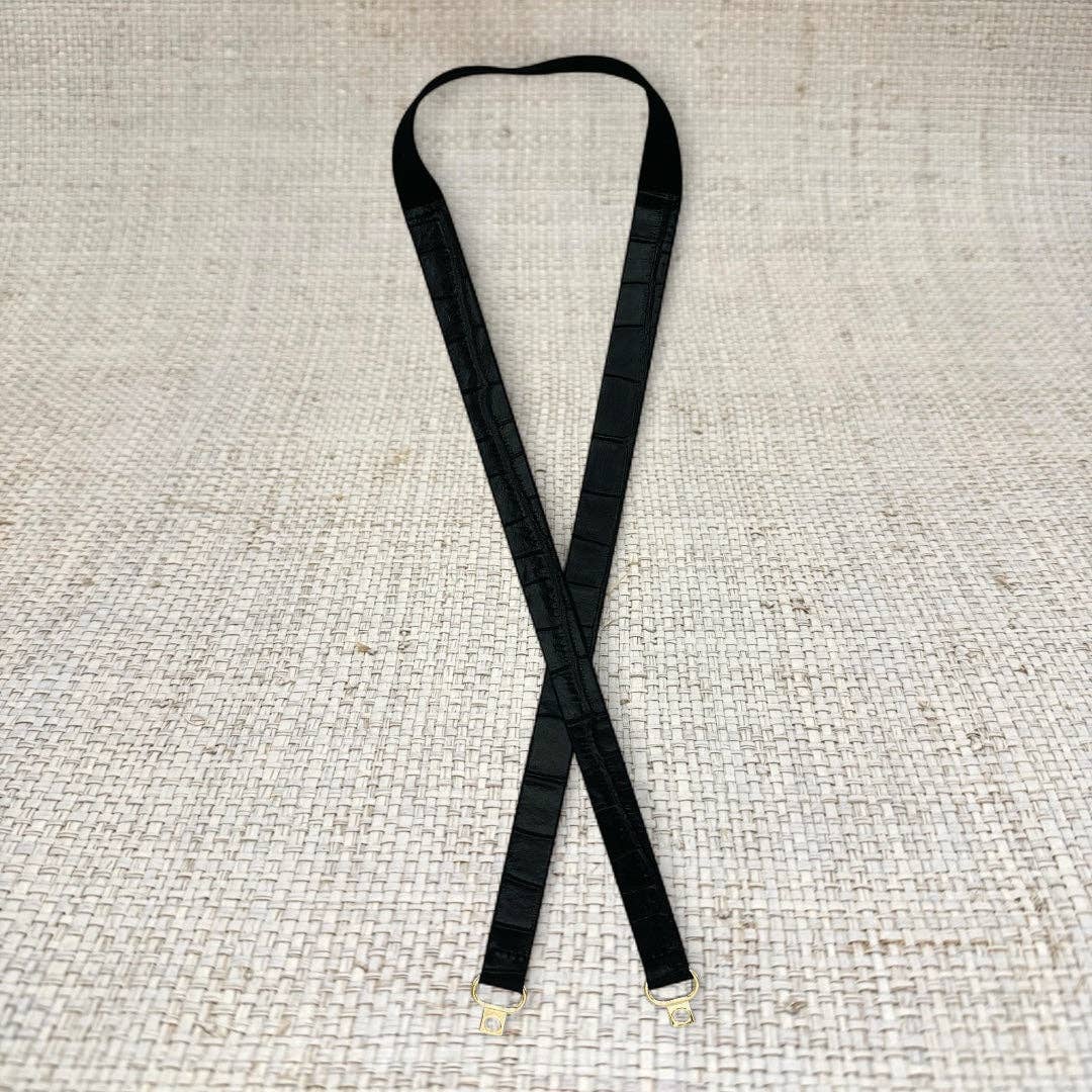 Black skinny leather belt from Garland Bags, close-up view showing sleek design and smooth leather strap.
