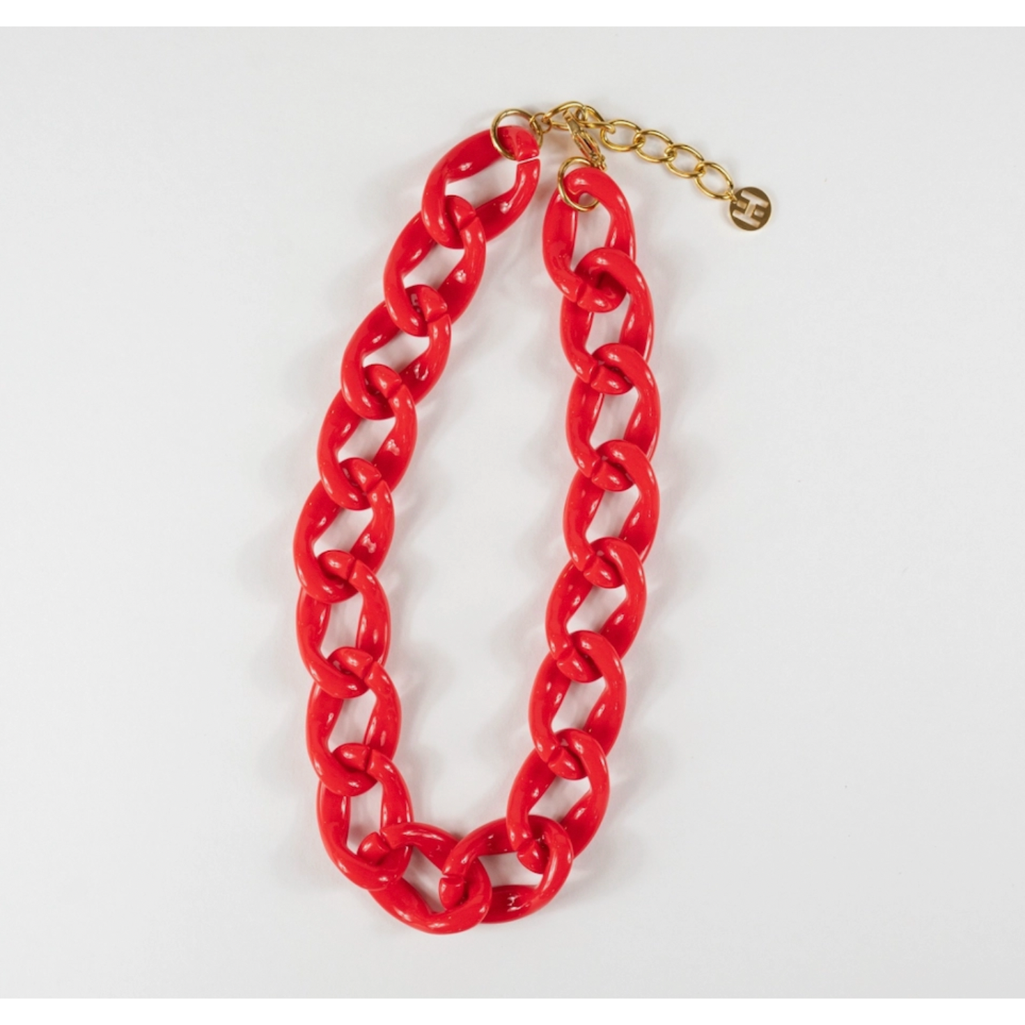 Red chain necklace with gold clasp on a white background
