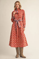 long-sleeve red midi dress with a white geometric pattern and a matching waist tie