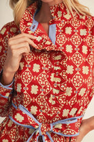 long-sleeve red midi dress with a white geometric pattern and a matching waist tie