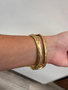 textured gold cuff bracelet with rose shaped flower