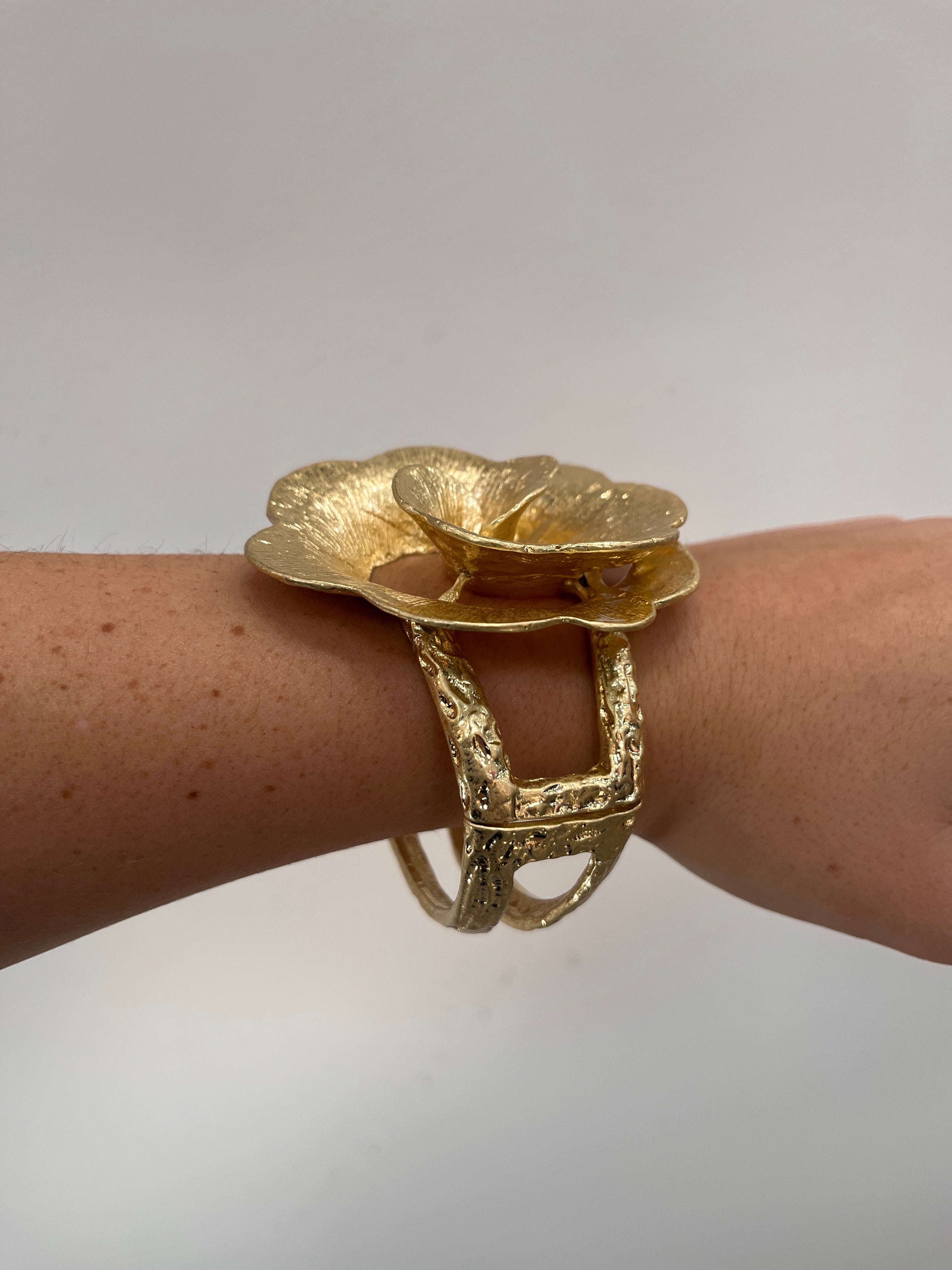 textured gold cuff bracelet with rose shaped flower
