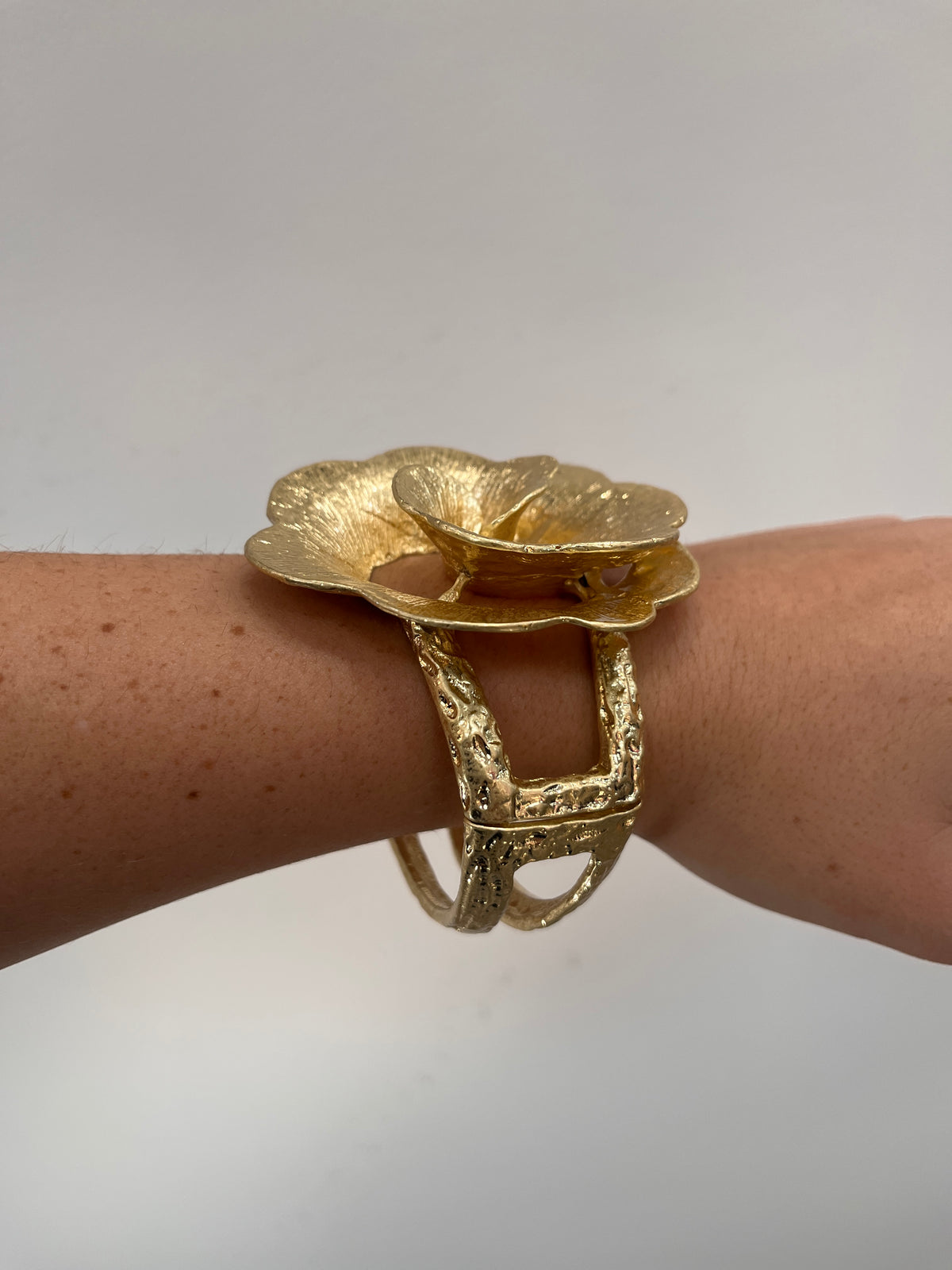 textured gold cuff bracelet with rose shaped flower