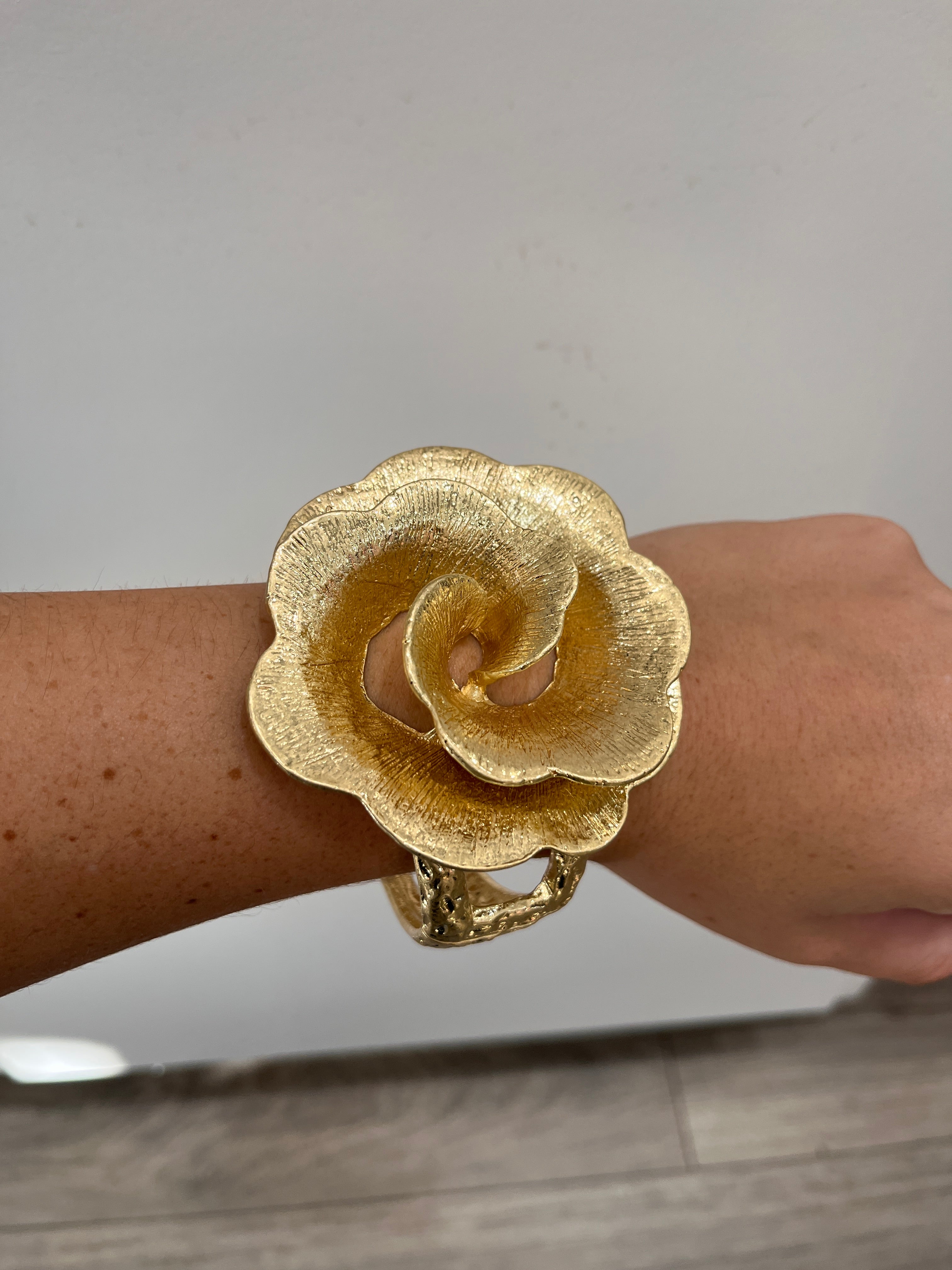 textured gold cuff bracelet with rose shaped flower
