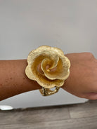 textured gold cuff bracelet with rose shaped flower