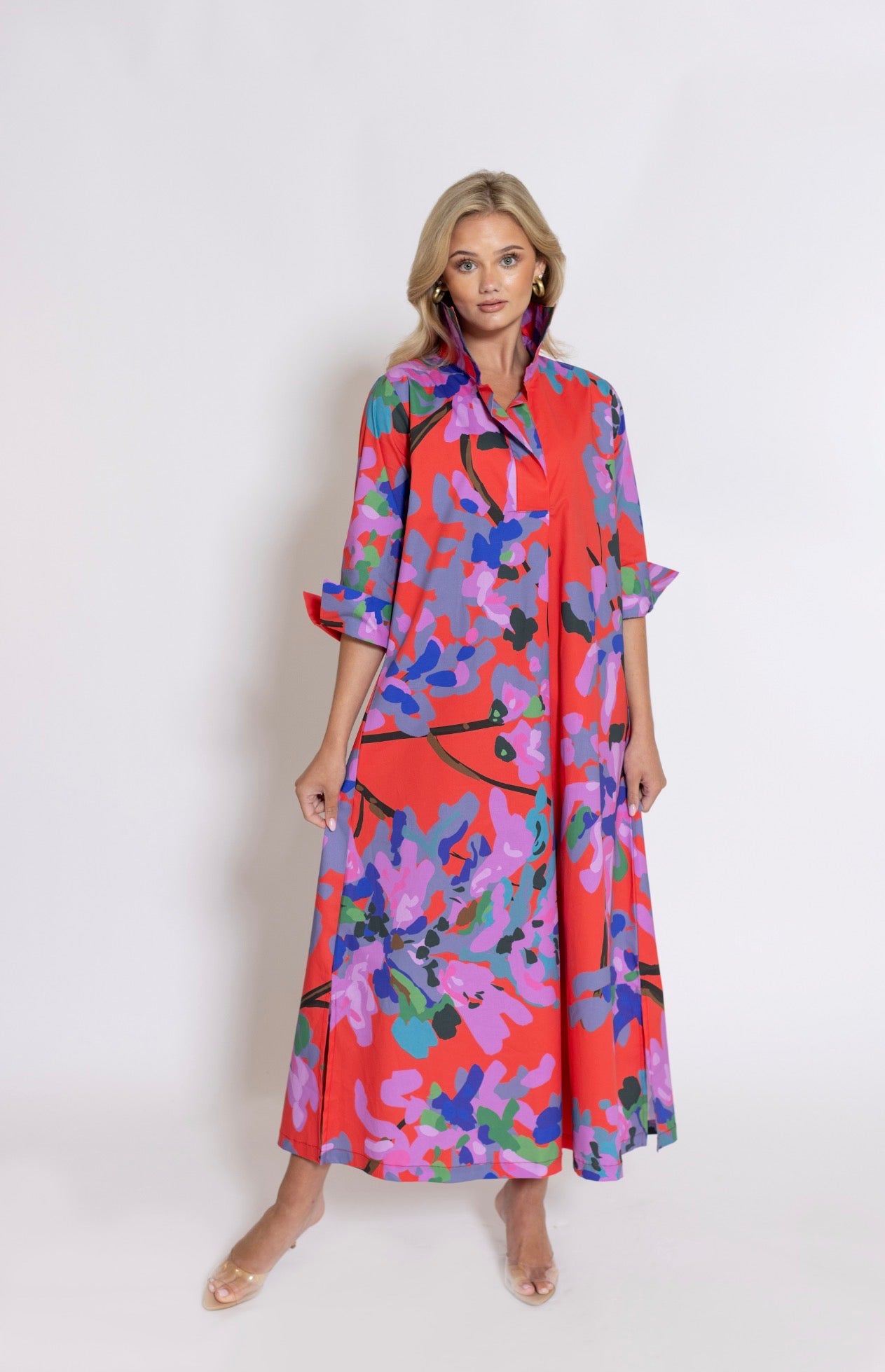 Miss Scarlet Ruthie Shirt Dress Long by House of MBR, front view, maxi shirt dress, bold red base with abstract floral print in lavender purple blue teal and green, shirt collar, 3/4 sleeves with split cuffs, relaxed A-line silhouette
