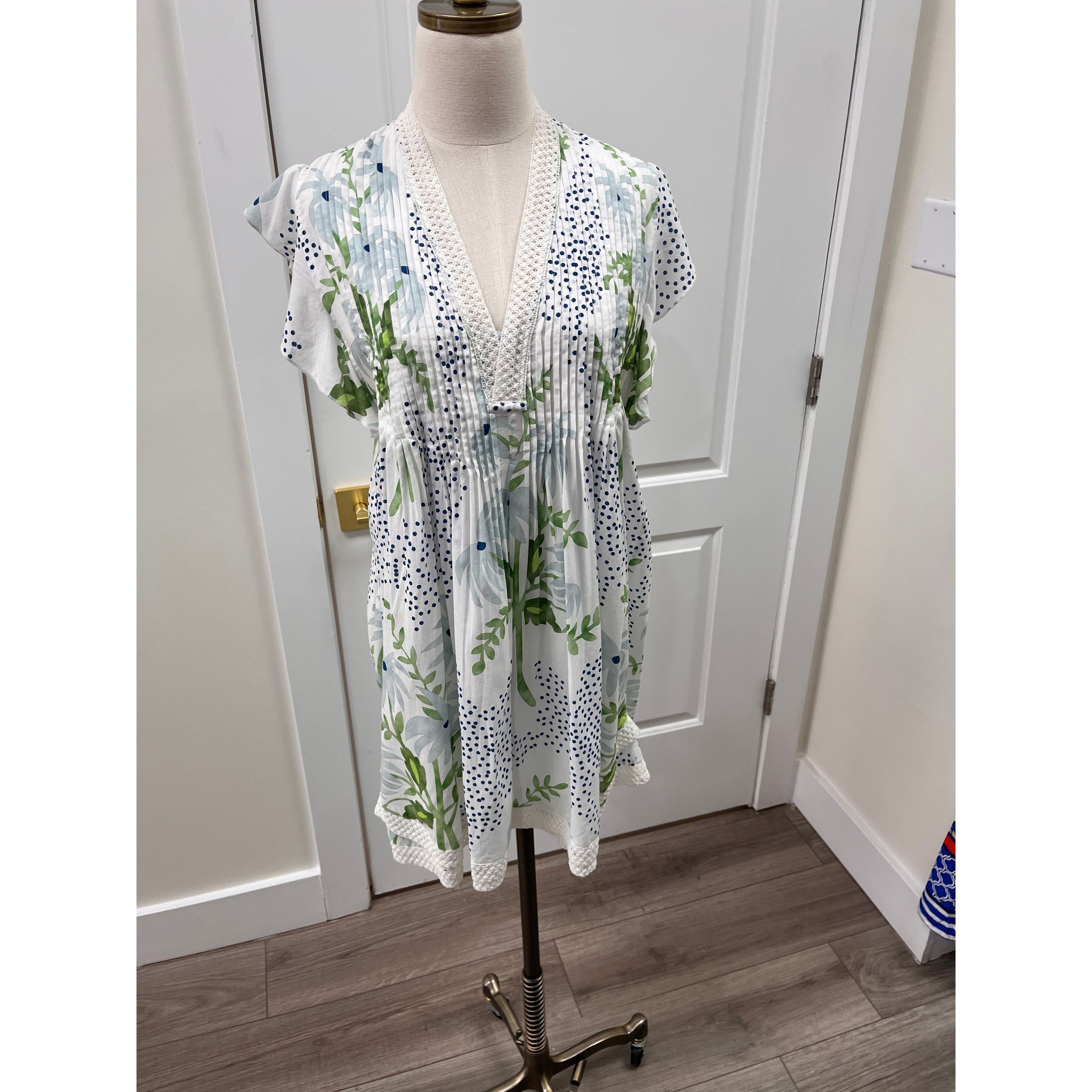 Navy Bleu Eden Dress displayed on a hanger, showcasing its elegant design and lightweight fabric in a natural setting.