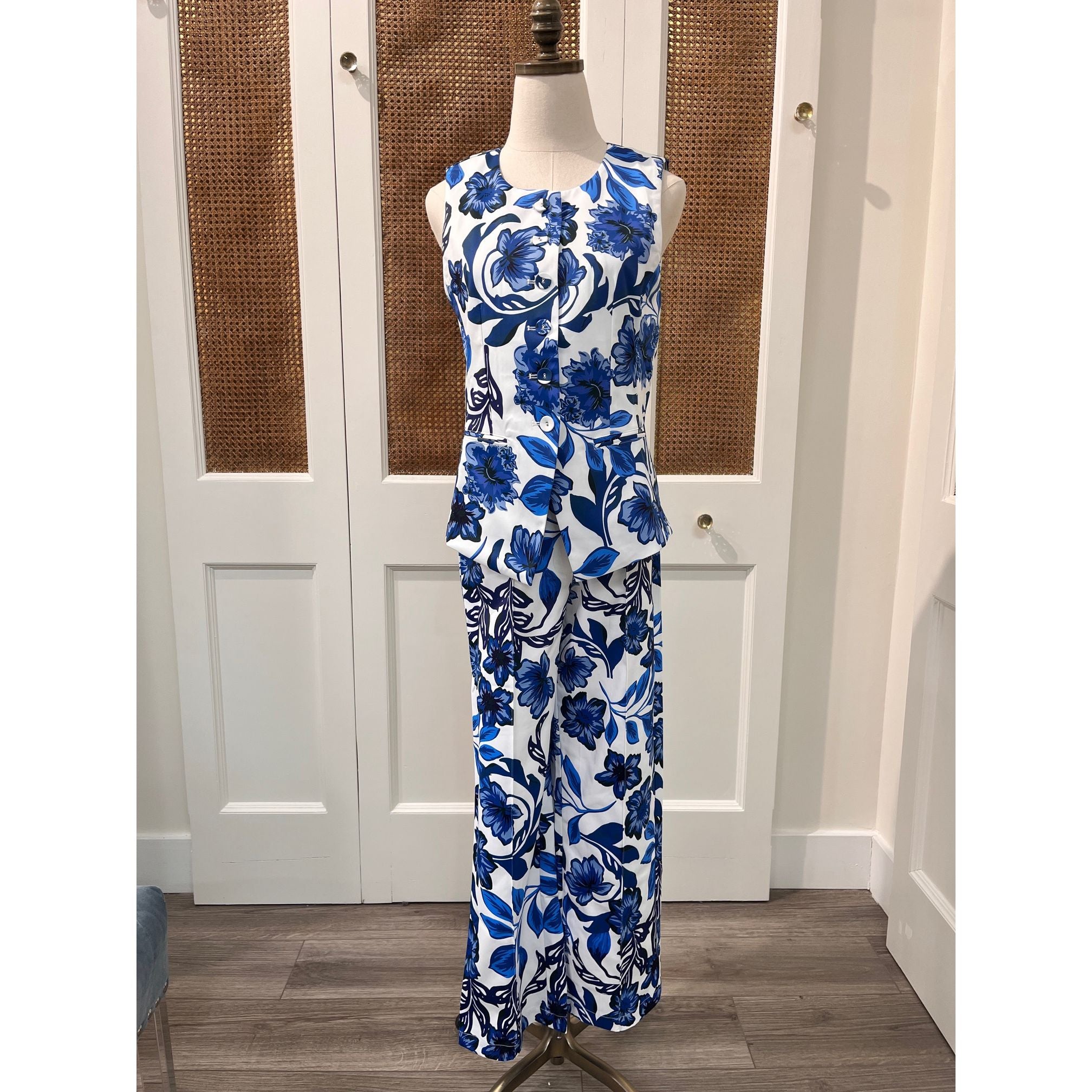 JADE Gladys top, stylish women's sleeveless blouse with floral pattern and V-neck, hanging on a hanger.