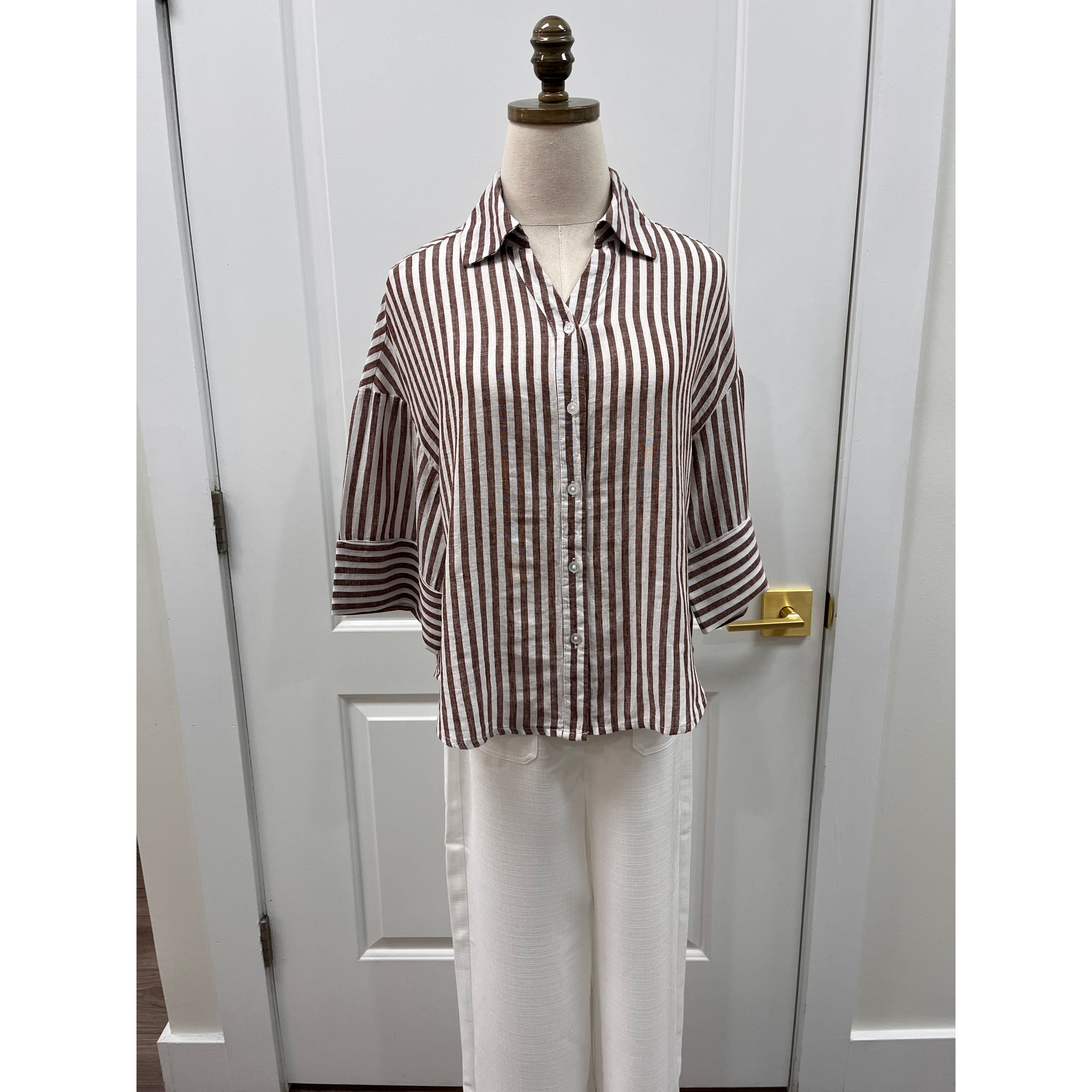Lola River Pixel Top displayed on a hanger, featuring a vibrant pixelated pattern and casual fit.