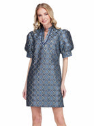  Georgia Dress by Jade in Gilded Trellis, front view, blue and gold metallic trellis jacquard, stand collar V-notch neckline trimmed in navy, puff sleeves, A-line shift silhouette