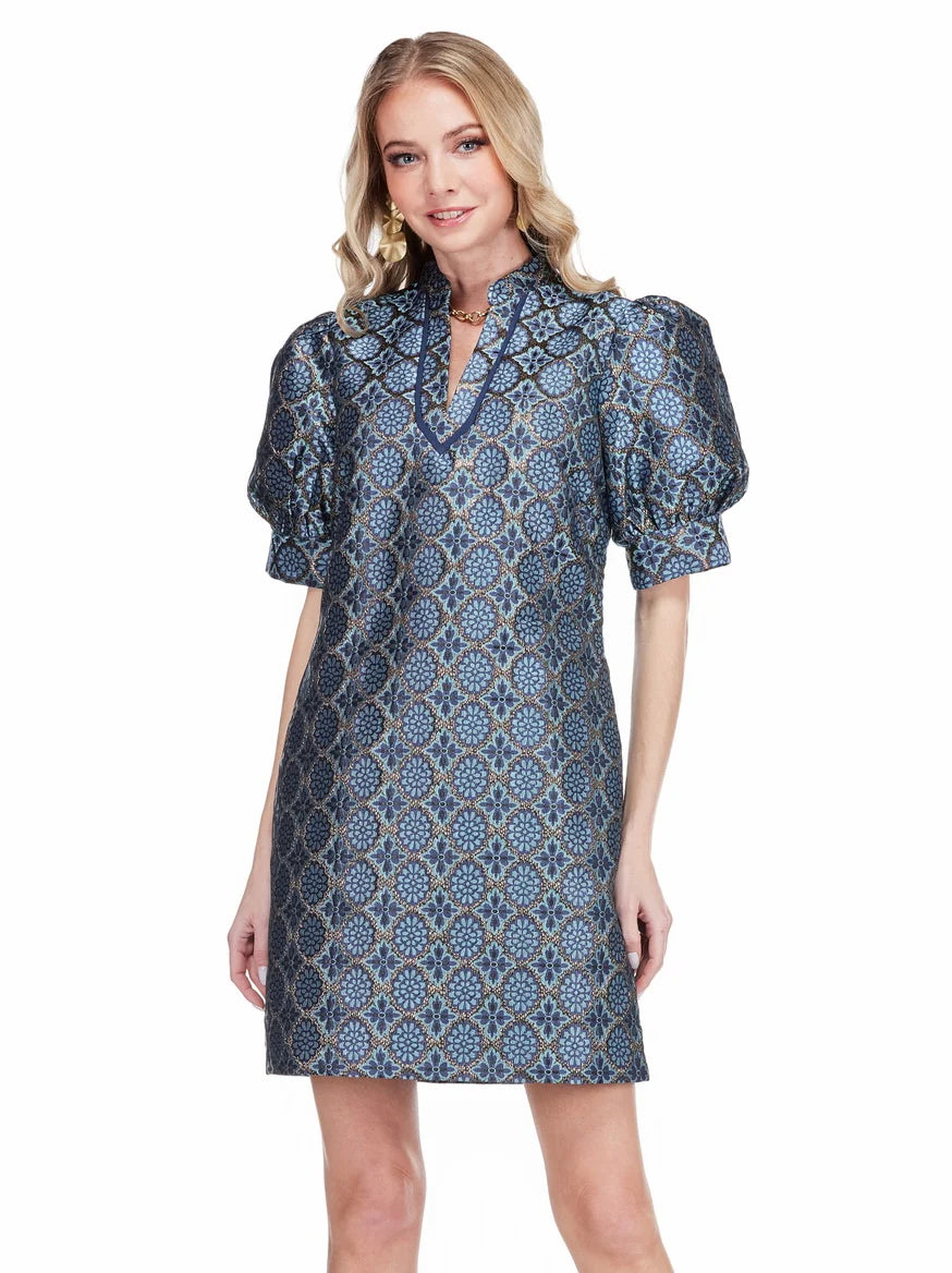  Georgia Dress by Jade in Gilded Trellis, front view, blue and gold metallic trellis jacquard, stand collar V-notch neckline trimmed in navy, puff sleeves, A-line shift silhouette