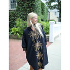 Navy Bleu Campbell dress in black with palm tree pattern, sleeveless design, and V-neck, perfect for casual or summer wear.