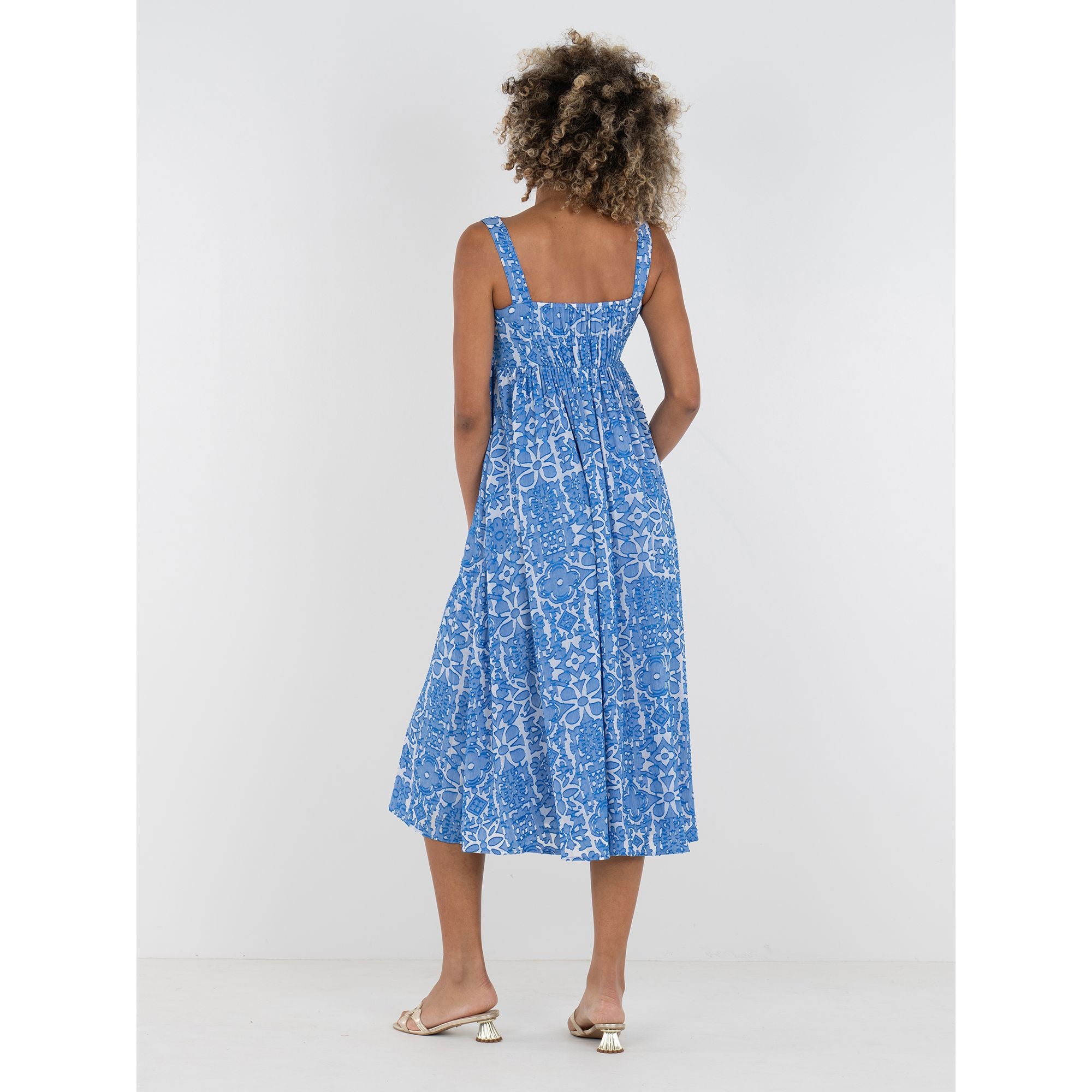 Emily McCarthy Capri dress with a flowy design, featuring a bright, patterned fabric and a back view in a Positano-inspired style.