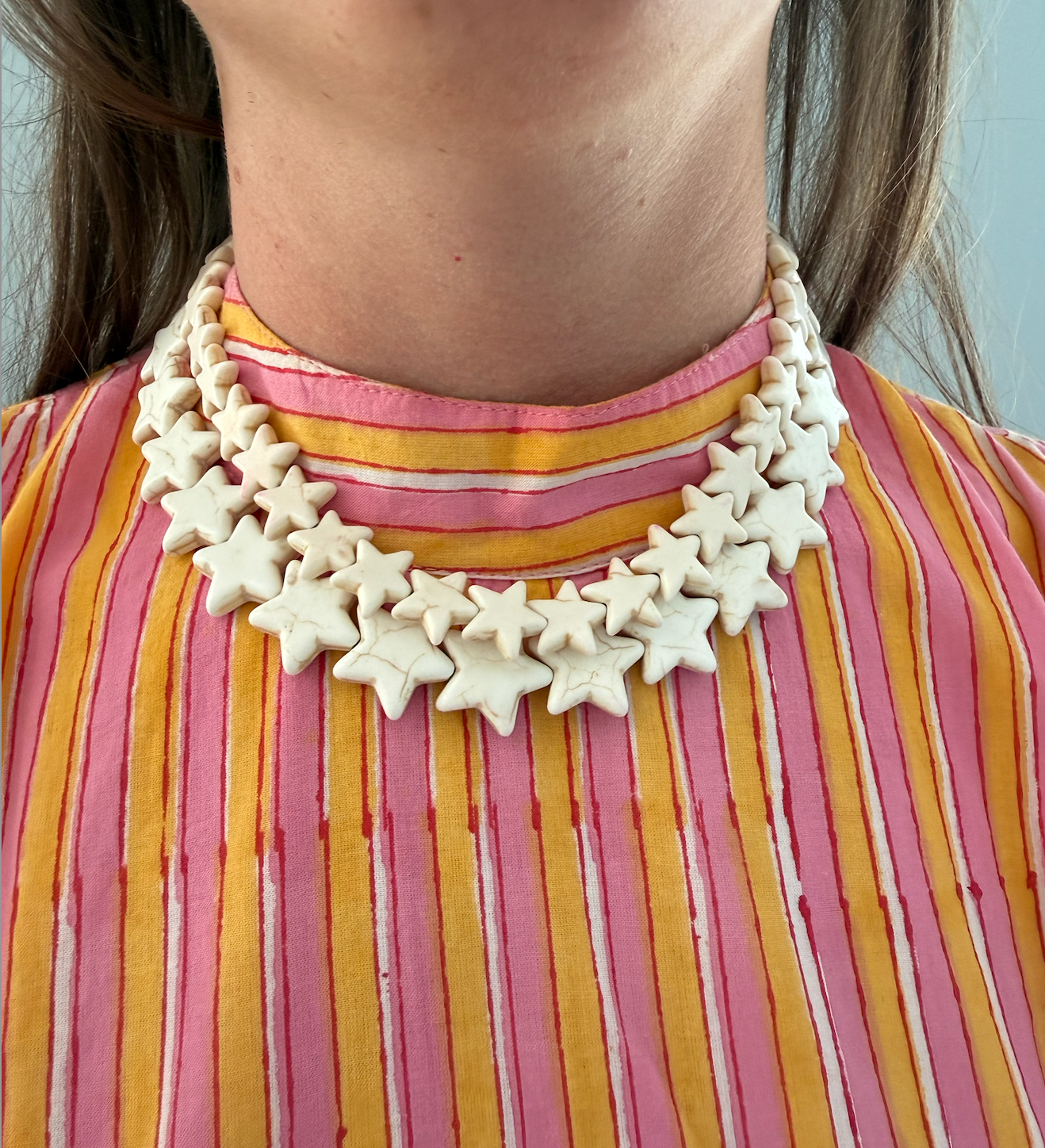 Star Necklace Small Coconut by Smith and Co. Design — cream star bead necklace layered on model
