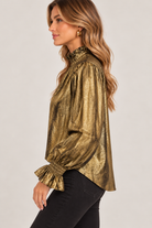 Maren Top by THML in olive-and-gold abstract print with a ruffled high neck, long sleeves, and smocked ruffle cuffs, side view.