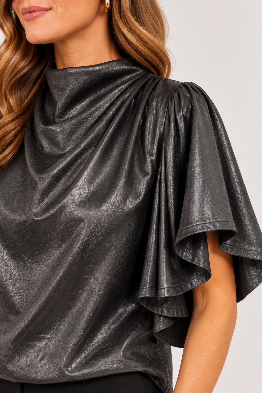  Close-up of the pleated shoulder and textured faux-leather finish on black Veronica Top, Style #WCT4008-1⠋