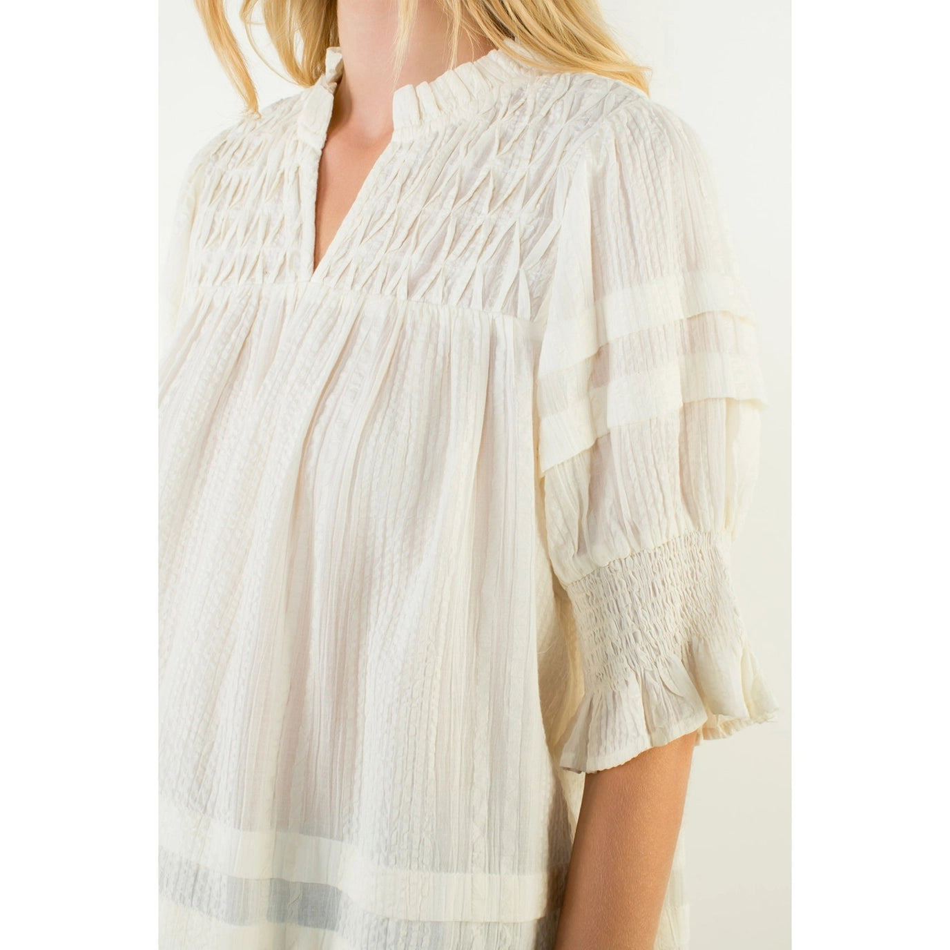 Cream-colored THML Davis Top with detailed fabric texture, close-up view showcasing stylish design and soft material.