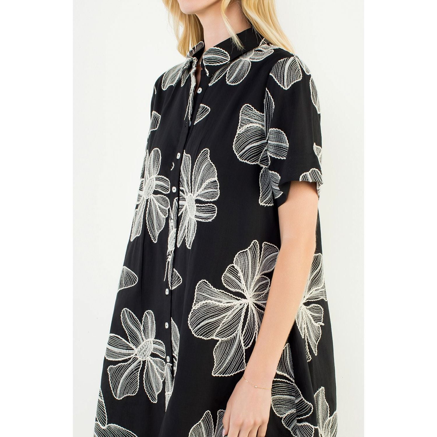 Maxine Dress by THML — close-up of white line-drawn floral embroidery on black fabric, collared neckline detail