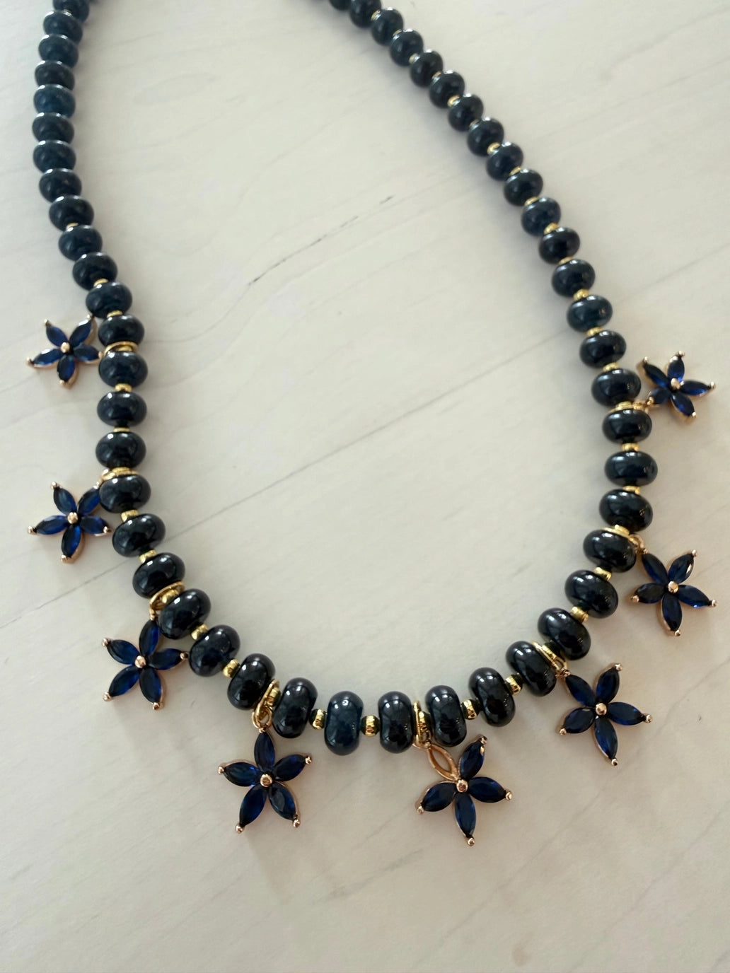 Beaded Bloom Necklace Navy by Smith and Co. Design — navy glass beads with CZ floral charms on marble
