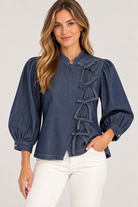 Lucy Top by Entro in dark denim with an off-center bow closure, band collar, and puffed sleeves, front view