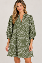 Susan Dress by Entro in olive with a curved cream motif, split V neckline, and smocked cuffs, front view