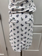 A white fabric-covered cylindrical support or handle with a repeating navy blue floral pattern, shown against a white paneled background.