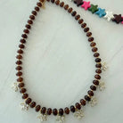 Beaded Bloom Necklace in Brown by Smith and Co. Design — chocolate brown glass beads with CZ floral charms close up