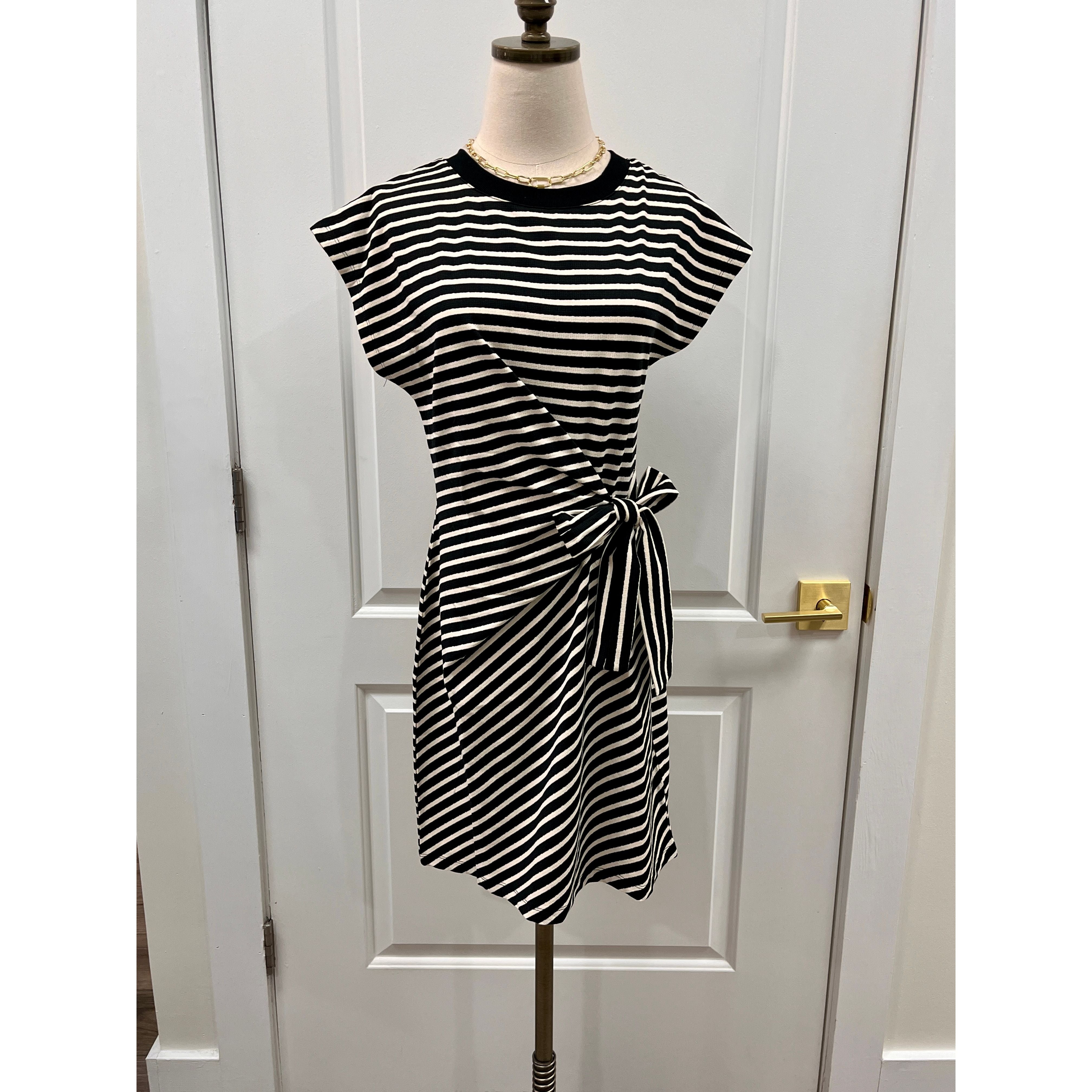 Staccato Selma dress in black and white striped sleeveless design, showcasing a stylish and modern dress for women.