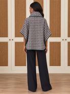 Dorothy Top by Voy in gray-and-ivory houndstooth with a cowl neck, wide sleeves, and deep green trim, back view
