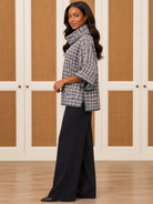 Dorothy Top by Voy in gray-and-ivory houndstooth with a cowl neck, wide sleeves, and deep green trim, side view